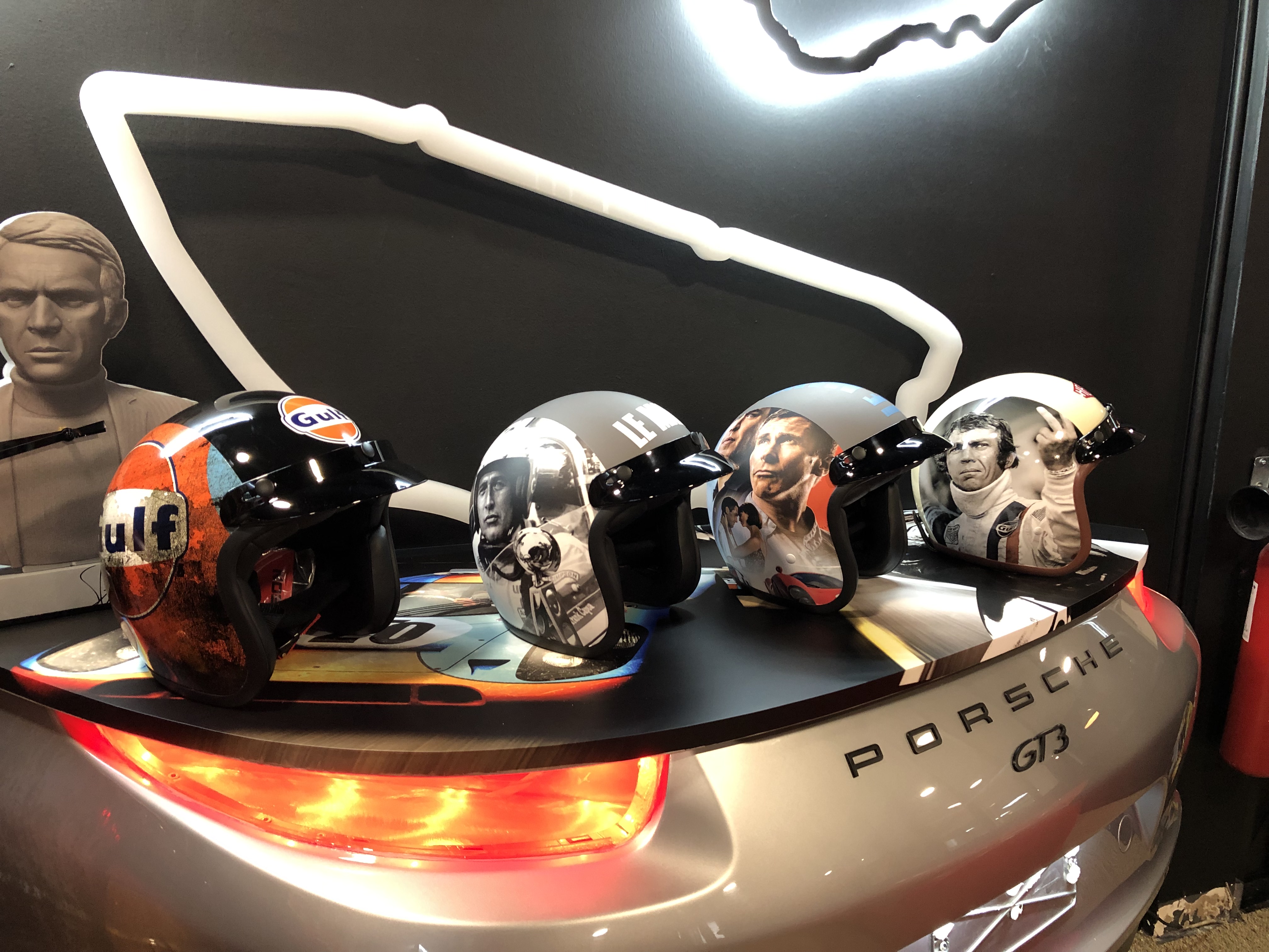 Collection de casques sur sculpture Porsche